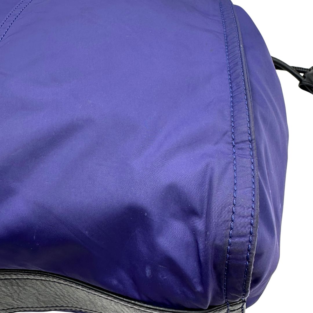 Borsa Burberry Tote Buckleigh in nylon viola con finiture in pelle nera e parti metalliche effetto renio. Munita di doppi manici, da indossare a spalla. Originale, usato, in condizioni ottime. 