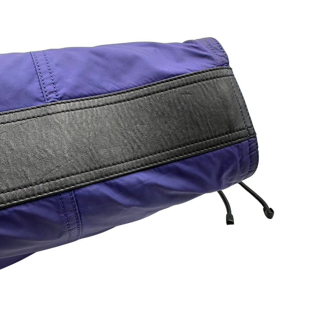 Borsa Burberry Tote Buckleigh in nylon viola con finiture in pelle nera e parti metalliche effetto renio. Munita di doppi manici, da indossare a spalla. Originale, usato, in condizioni ottime. 