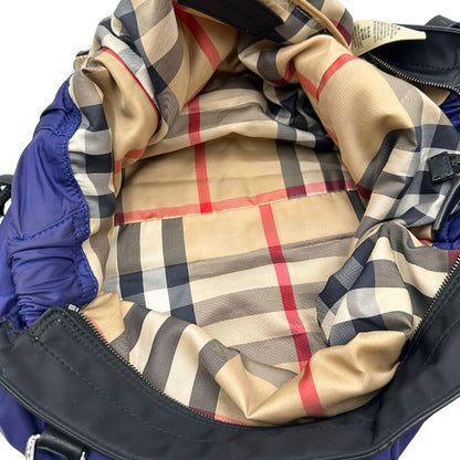 Borsa Burberry Tote Buckleigh in nylon viola con finiture in pelle nera e parti metalliche effetto renio. Munita di doppi manici, da indossare a spalla. Originale, usato, in condizioni ottime. 