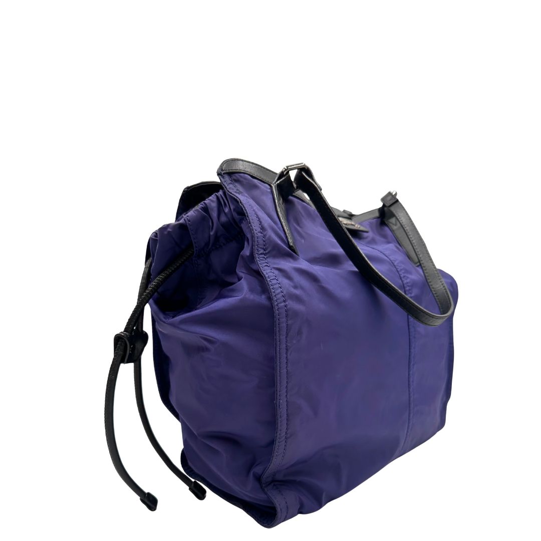 Borsa Burberry Tote Buckleigh in nylon viola con finiture in pelle nera e parti metalliche effetto renio. Munita di doppi manici, da indossare a spalla. Originale, usato, in condizioni ottime. 