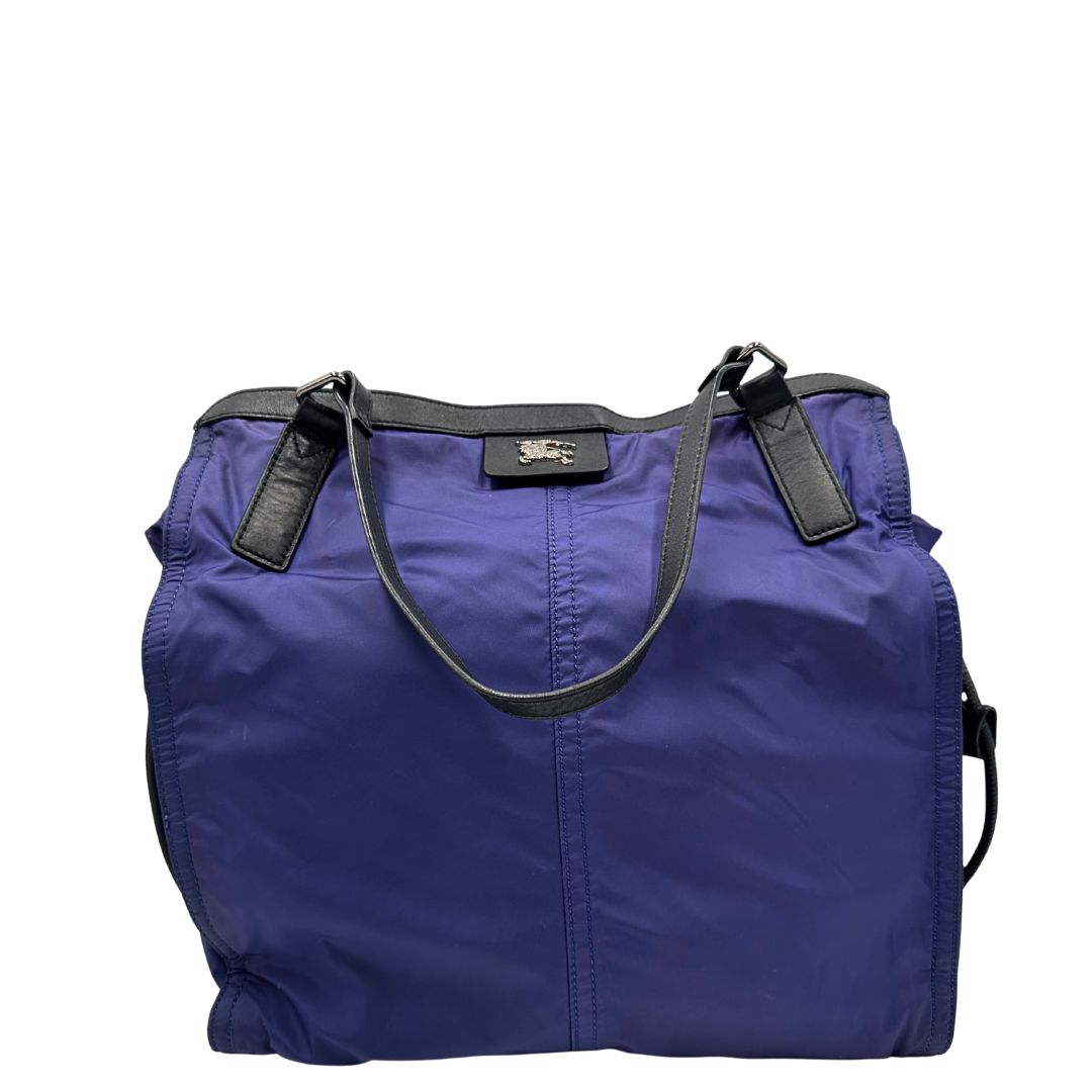 Borsa Burberry Tote Buckleigh in nylon viola con finiture in pelle nera e parti metalliche effetto renio. Munita di doppi manici, da indossare a spalla. Originale, usato, in condizioni ottime. 
