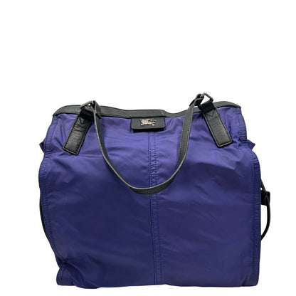 Borsa Burberry Tote Buckleigh in nylon viola con finiture in pelle nera e parti metalliche effetto renio. Munita di doppi manici, da indossare a spalla. Originale, usato, in condizioni ottime. 
