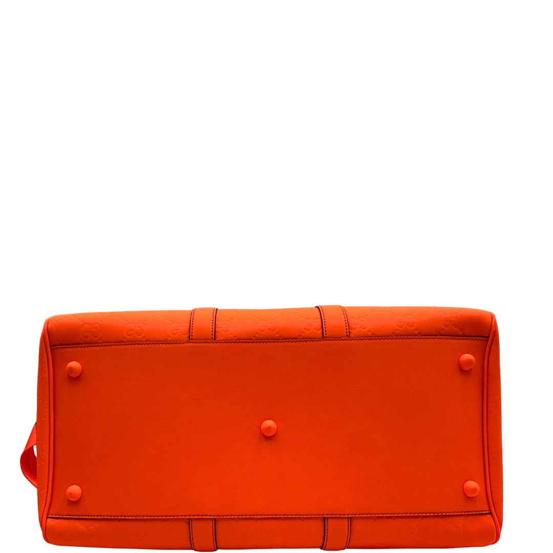 base Borsone Gucci in pelle arancione fluo monogram; munito di doppi manici stondati e una tracolla regolabile in tessuto. Completo di dustbag. 