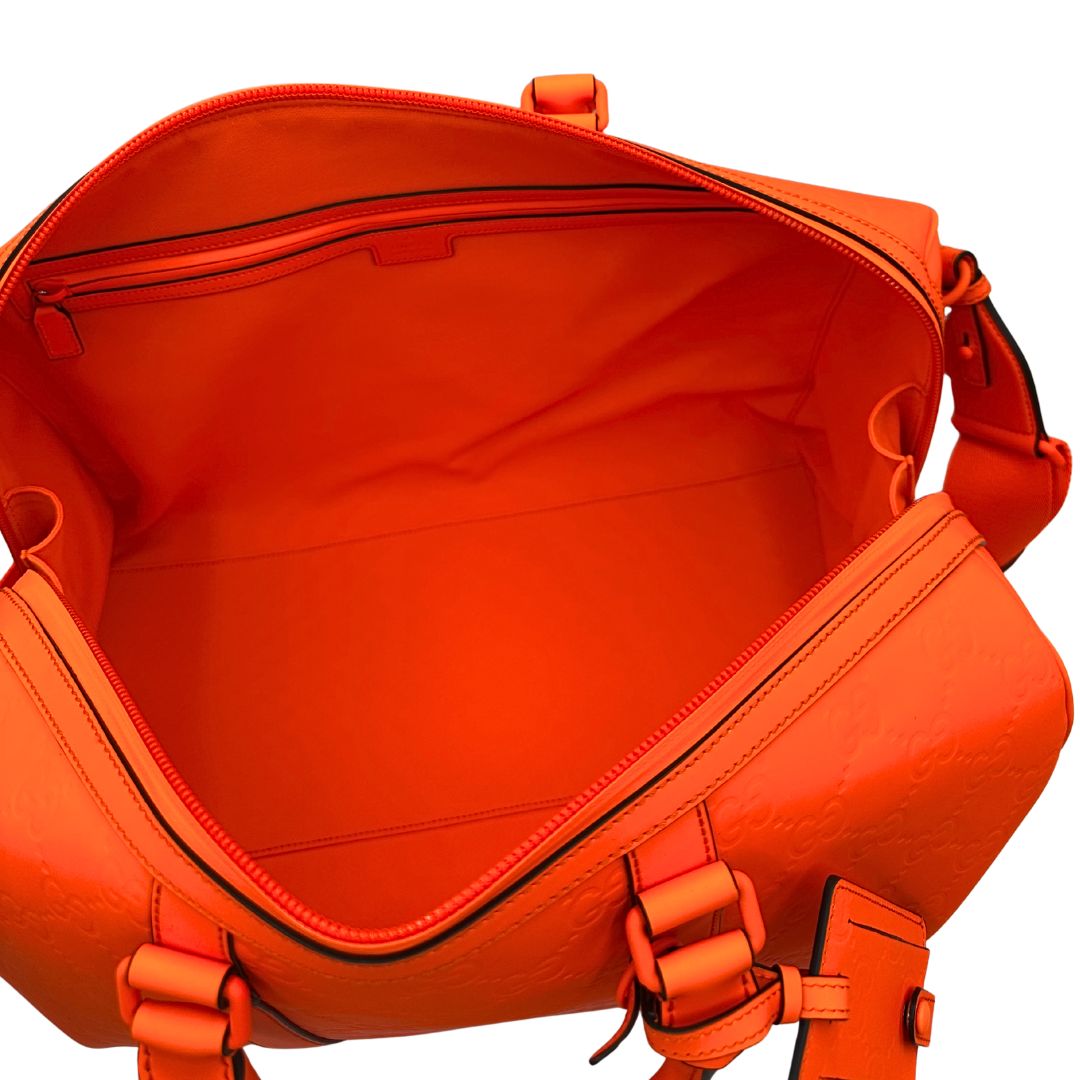 interno Borsone Gucci in pelle arancione fluo monogram; munito di doppi manici stondati e una tracolla regolabile in tessuto. Completo di dustbag. 