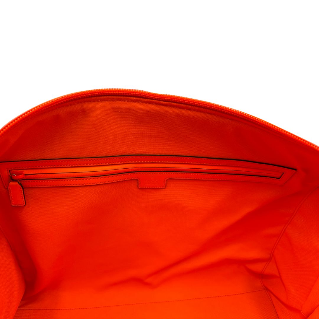 interno Borsone Gucci in pelle arancione fluo monogram; munito di doppi manici stondati e una tracolla regolabile in tessuto. Completo di dustbag. 