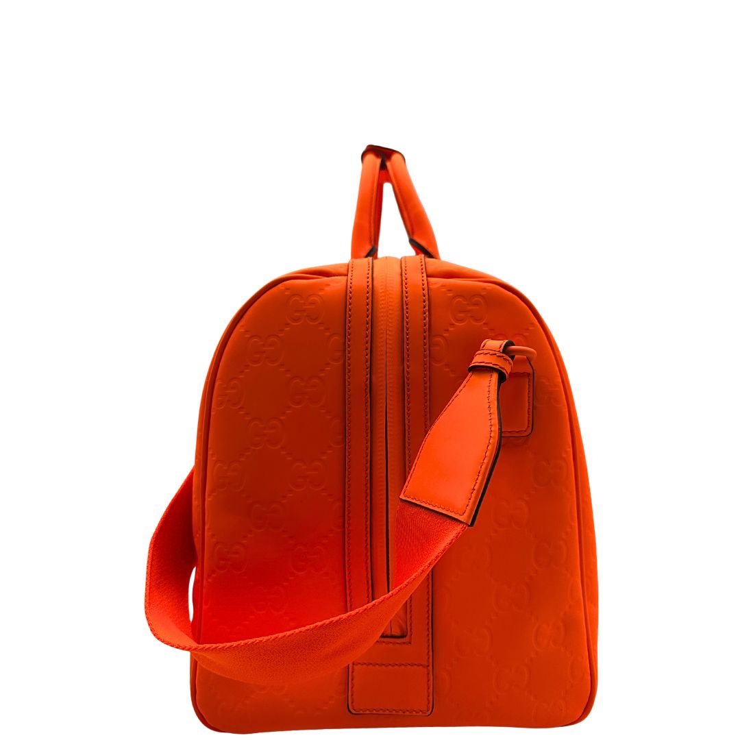 lato Borsone Gucci in pelle arancione fluo monogram; munito di doppi manici stondati e una tracolla regolabile in tessuto. Completo di dustbag. 