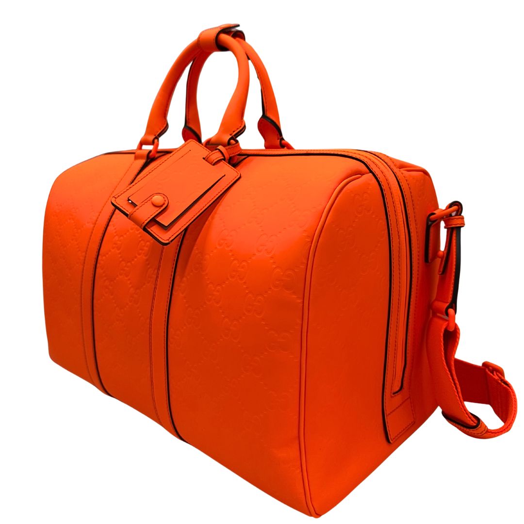 lato Borsone Gucci in pelle arancione fluo monogram; munito di doppi manici stondati e una tracolla regolabile in tessuto. Completo di dustbag. 