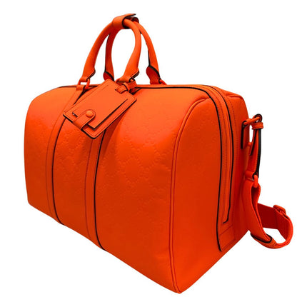 lato Borsone Gucci in pelle arancione fluo monogram; munito di doppi manici stondati e una tracolla regolabile in tessuto. Completo di dustbag. 