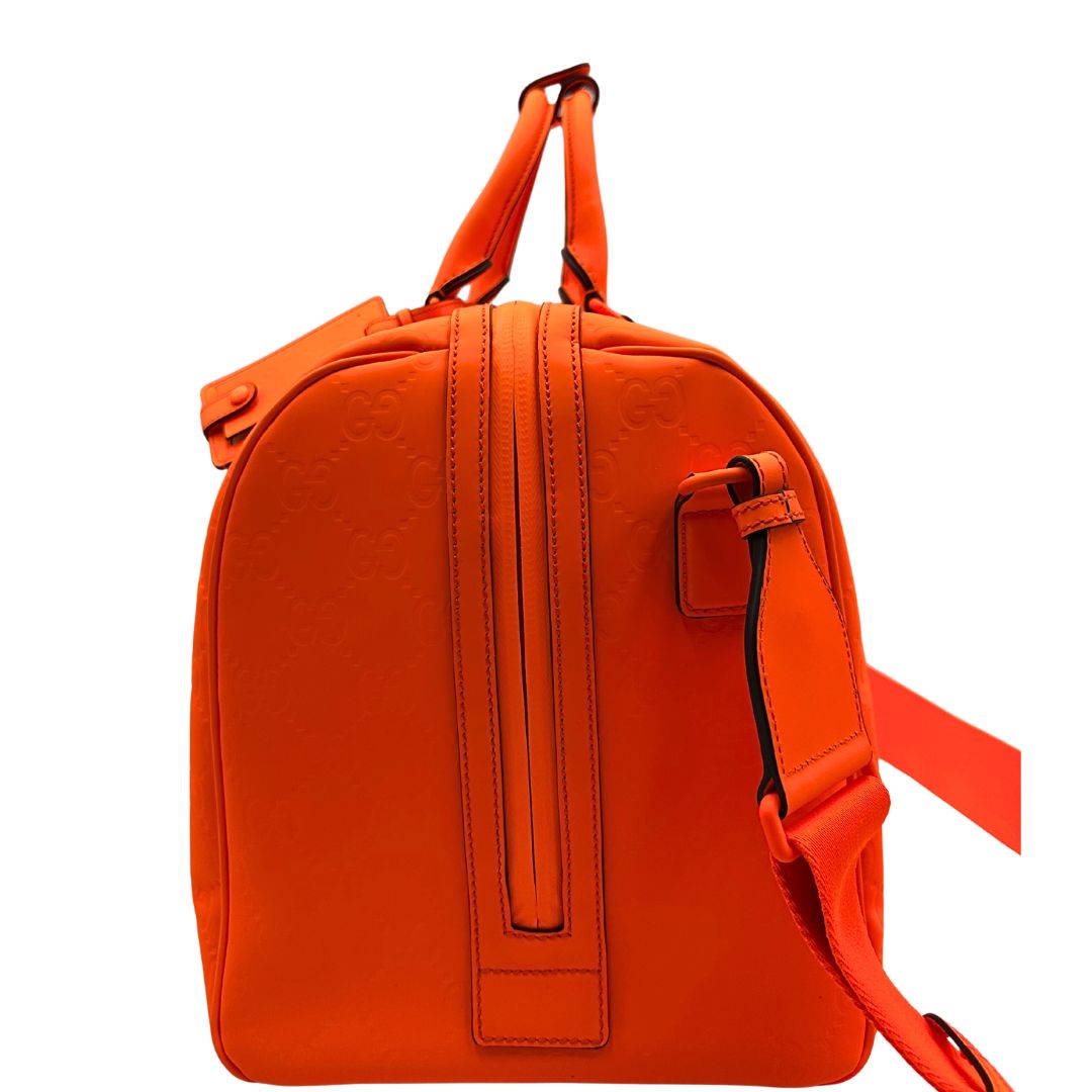 lato Borsone Gucci in pelle arancione fluo monogram; munito di doppi manici stondati e una tracolla regolabile in tessuto. Completo di dustbag. 