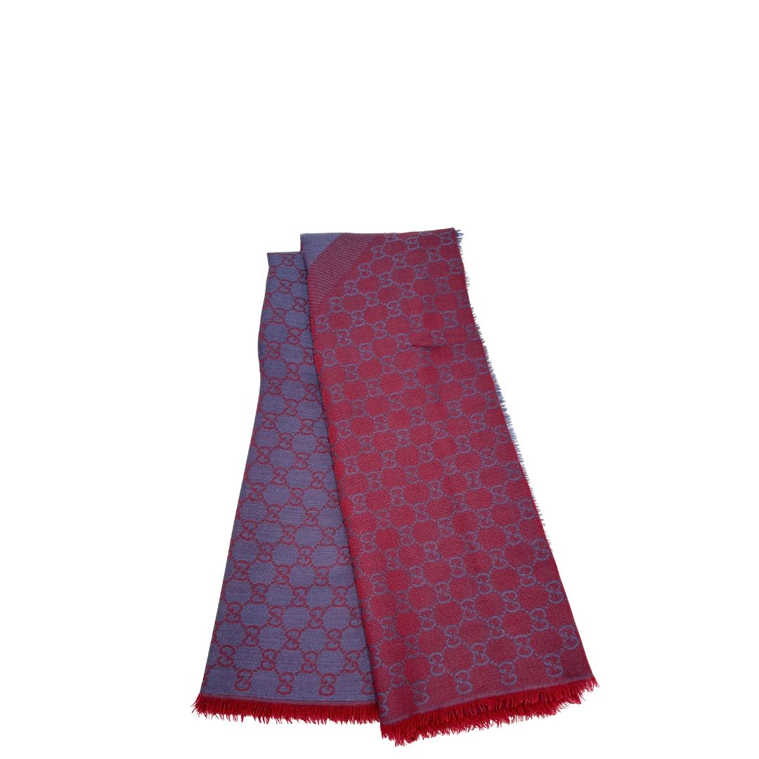 Scialle Gucci in misto lana e seta bicolore; bordeaux e blu con trama GG, e bori sfrangiati. Completo di scatola. Originale, usato, in condizioni ottime. 