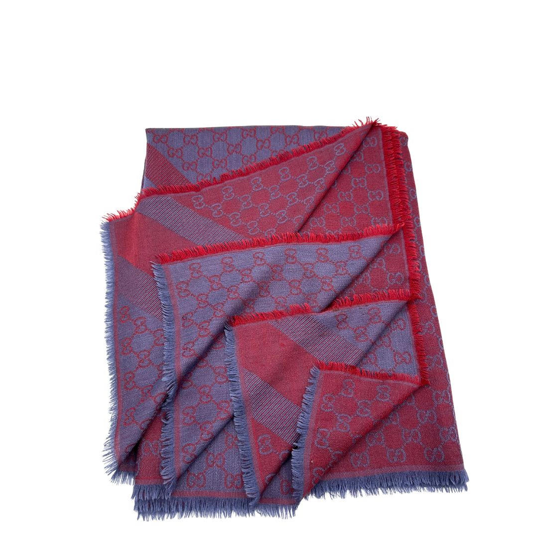 Scialle Gucci in misto lana e seta bicolore; bordeaux e blu con trama GG, e bori sfrangiati. Completo di scatola. Originale, usato, in condizioni ottime. 