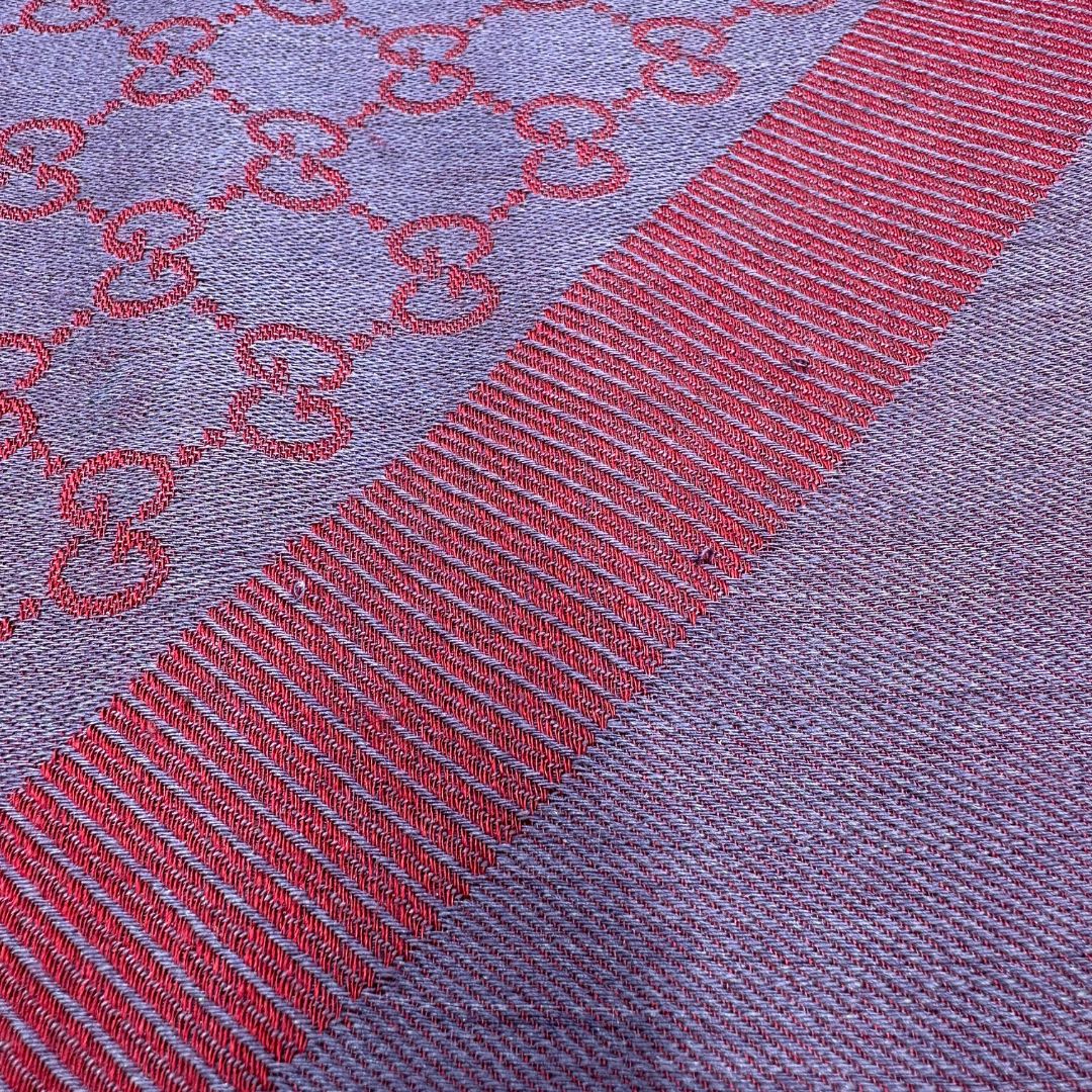 Scialle Gucci in misto lana e seta bicolore; bordeaux e blu con trama GG, e bori sfrangiati. Completo di scatola. Originale, usato, in condizioni ottime. 