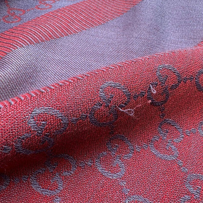 Scialle Gucci in misto lana e seta bicolore; bordeaux e blu con trama GG, e bori sfrangiati. Completo di scatola. Originale, usato, in condizioni ottime. 