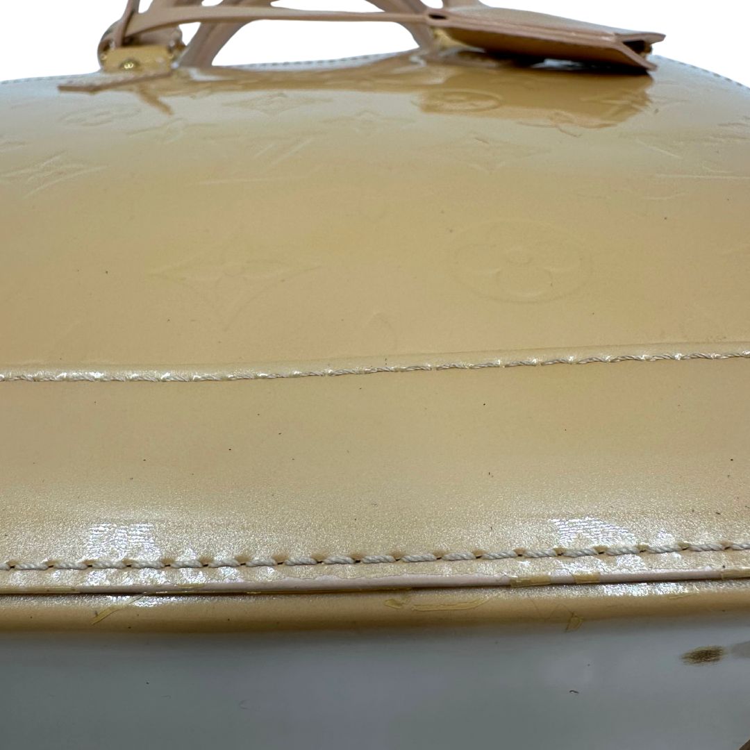 Alma PM Louis Vuitton in pelle Vernis color noisette con parti metalliche dorate e doppi manici stondati; da portare a mano. Originale, usato, in condizioni ottime. 