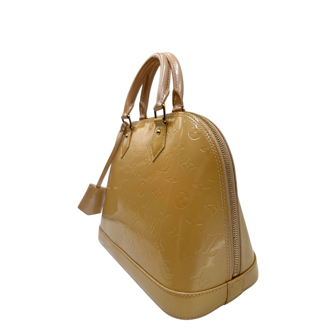 Laterale Alma PM Louis Vuitton in pelle Vernis color noisette con parti metalliche dorate e doppi manici stondati; da portare a mano. Originale, usato, in condizioni ottime. 