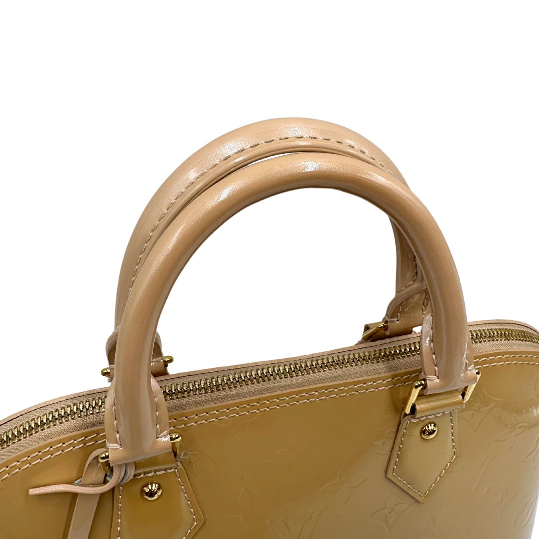Alma PM Louis Vuitton in pelle Vernis color noisette con parti metalliche dorate e doppi manici stondati; da portare a mano. Originale, usato, in condizioni ottime. 