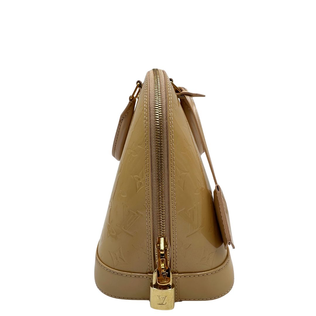 Laterale Alma PM Louis Vuitton in pelle Vernis color noisette con parti metalliche dorate e doppi manici stondati; da portare a mano. Originale, usato, in condizioni ottime. 