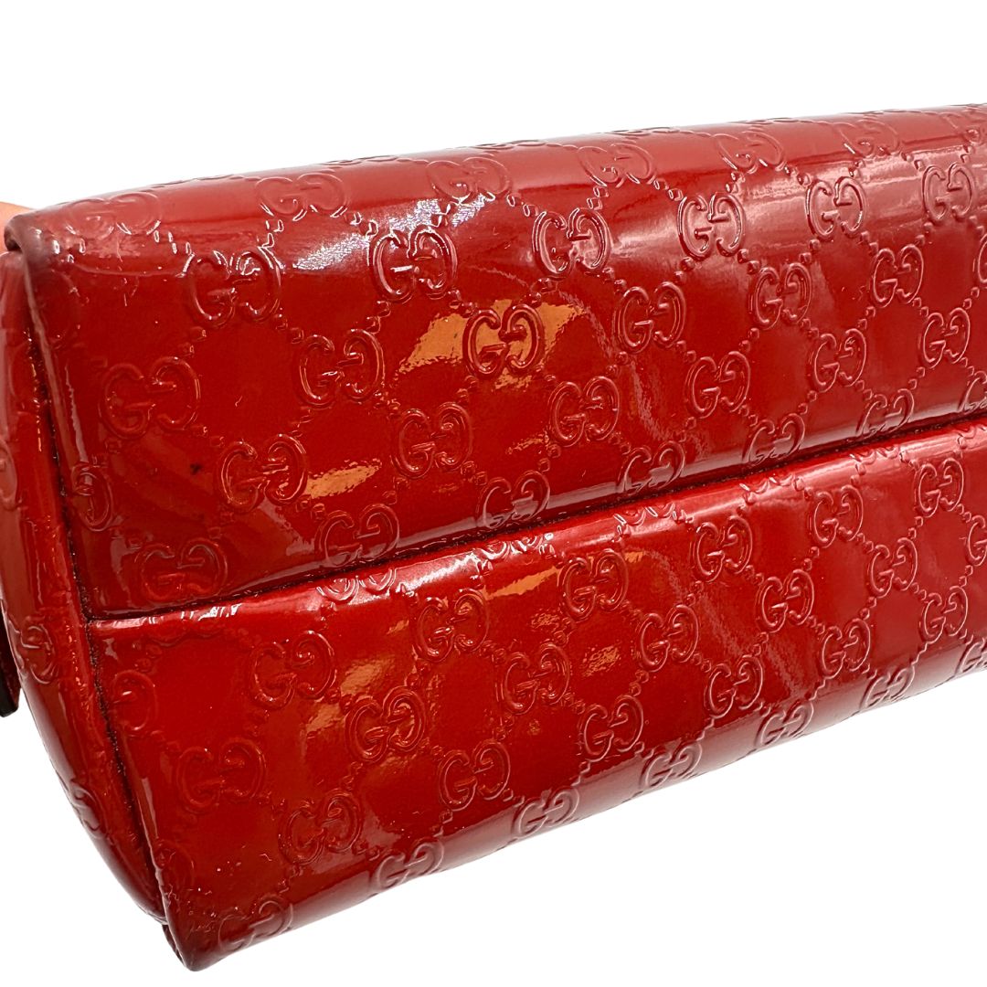 Pochette in pelle rossa verniciata monogram con parti metalliche dorate. Completa di dustbag, di lusso, originale, ottime condizioni