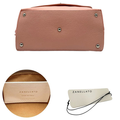 Base e codici di una borsa Zanellato in nylon rosa e parti in pelle tono su tono. Dettagli metallici argentati; munita di un manico con nodi e una tracolla amovibile e regolabile. Completa di dustbag.