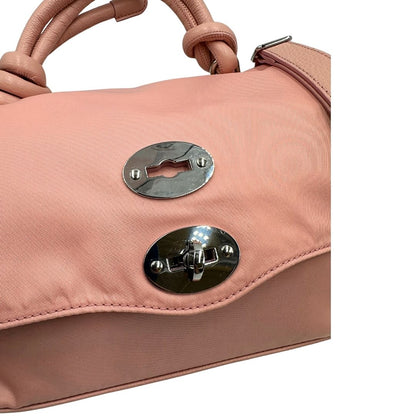 Chiusura di una borsa Zanellato in nylon rosa e parti in pelle tono su tono. Dettagli metallici argentati; munita di un manico con nodi e una tracolla amovibile e regolabile. Completa di dustbag.