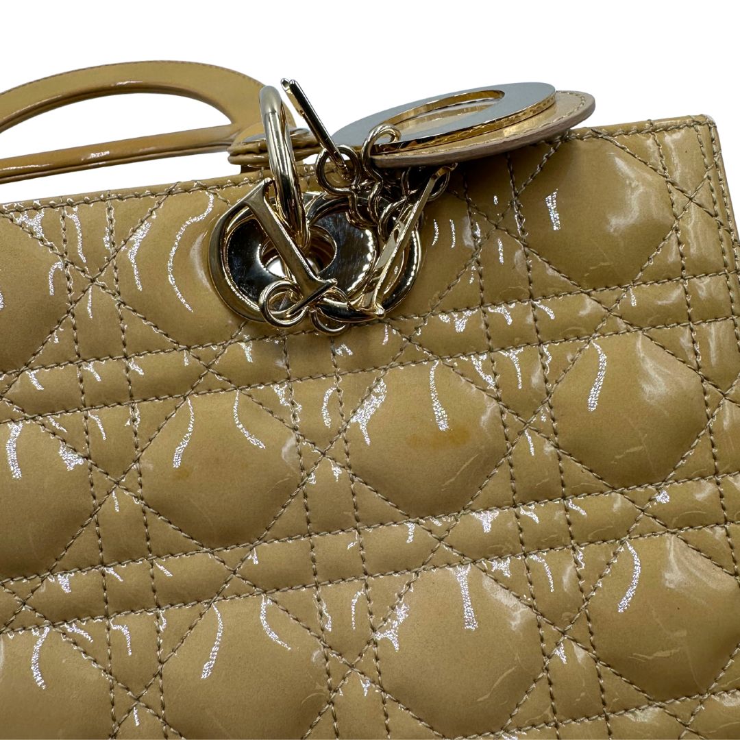 Borsa Lady Dior Large in pelle verniciata in trama cannage giallo ocra chiaro. Doppi manici rigidi e una tracolla amovibile, rifinita con parti metalliche argentate. Completa di corredo. Originale, usato, in condizioni ottime. 