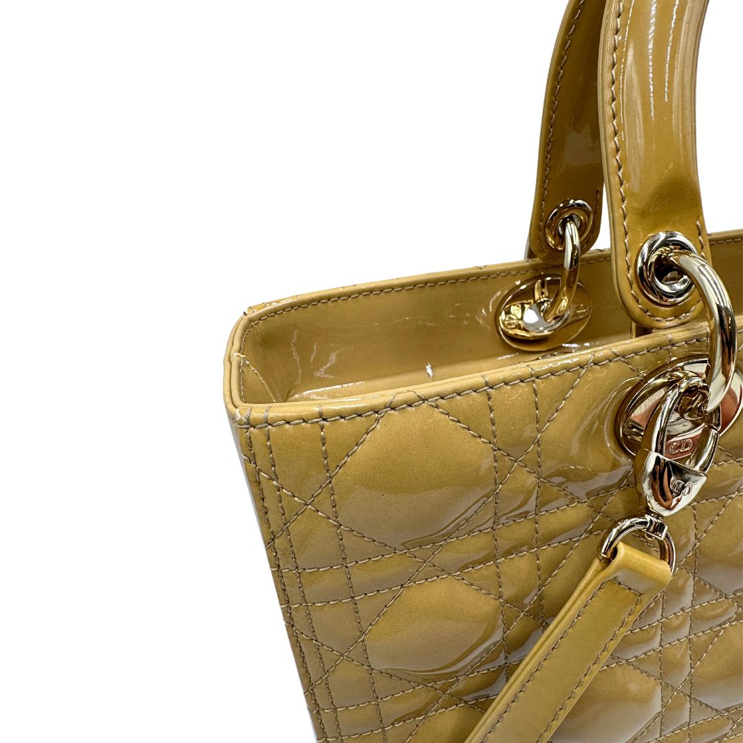Borsa Lady Dior Large in pelle verniciata in trama cannage giallo ocra chiaro. Doppi manici rigidi e una tracolla amovibile, rifinita con parti metalliche argentate. Completa di corredo. Originale, usato, in condizioni ottime. 