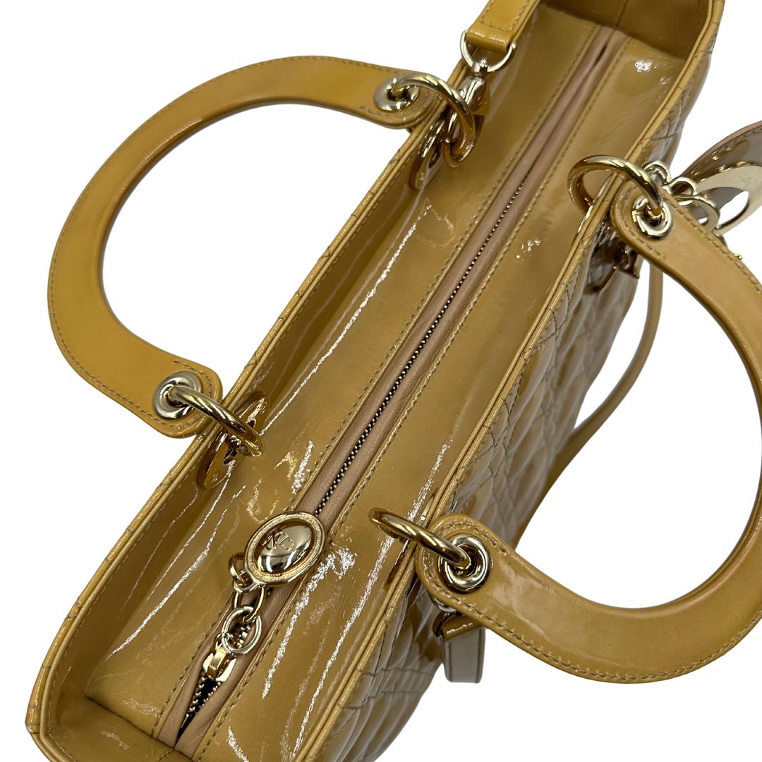 Borsa Lady Dior Large in pelle verniciata in trama cannage giallo ocra chiaro. Doppi manici rigidi e una tracolla amovibile, rifinita con parti metalliche argentate. Completa di corredo. Originale, usato, in condizioni ottime. 