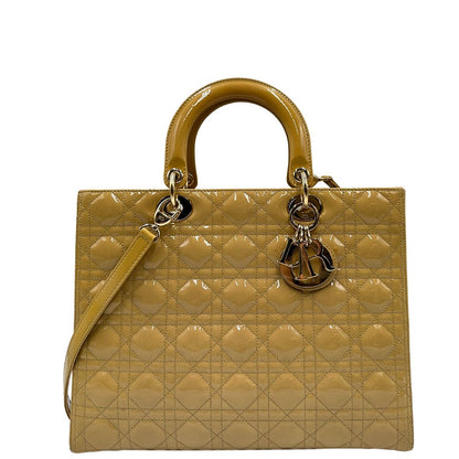 Borsa Lady Dior Large in pelle verniciata in trama cannage giallo ocra chiaro. Doppi manici rigidi e una tracolla amovibile, rifinita con parti metalliche argentate. Completa di corredo. Originale, usato, in condizioni ottime. 