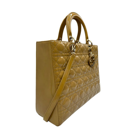 Laterale Borsa Lady Dior Large in pelle verniciata in trama cannage giallo ocra chiaro. Doppi manici rigidi e una tracolla amovibile, rifinita con parti metalliche argentate. Completa di corredo. Originale, usato, in condizioni ottime. 