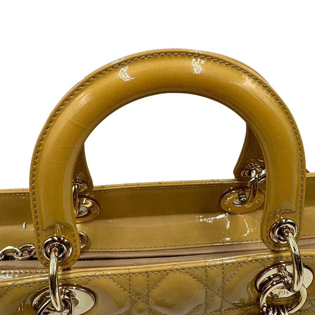Borsa Lady Dior Large in pelle verniciata in trama cannage giallo ocra chiaro. Doppi manici rigidi e una tracolla amovibile, rifinita con parti metalliche argentate. Completa di corredo. Originale, usato, in condizioni ottime. 