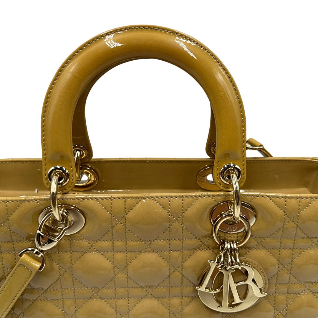 Borsa Lady Dior Large in pelle verniciata in trama cannage giallo ocra chiaro. Doppi manici rigidi e una tracolla amovibile, rifinita con parti metalliche argentate. Completa di corredo. Originale, usato, in condizioni ottime. 