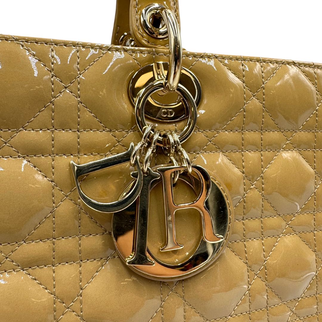 Borsa Lady Dior Large in pelle verniciata in trama cannage giallo ocra chiaro. Doppi manici rigidi e una tracolla amovibile, rifinita con parti metalliche argentate. Completa di corredo. Originale, usato, in condizioni ottime. 