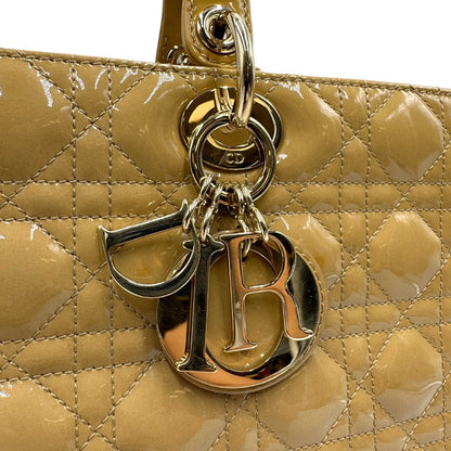 Borsa Lady Dior Large in pelle verniciata in trama cannage giallo ocra chiaro. Doppi manici rigidi e una tracolla amovibile, rifinita con parti metalliche argentate. Completa di corredo. Originale, usato, in condizioni ottime. 