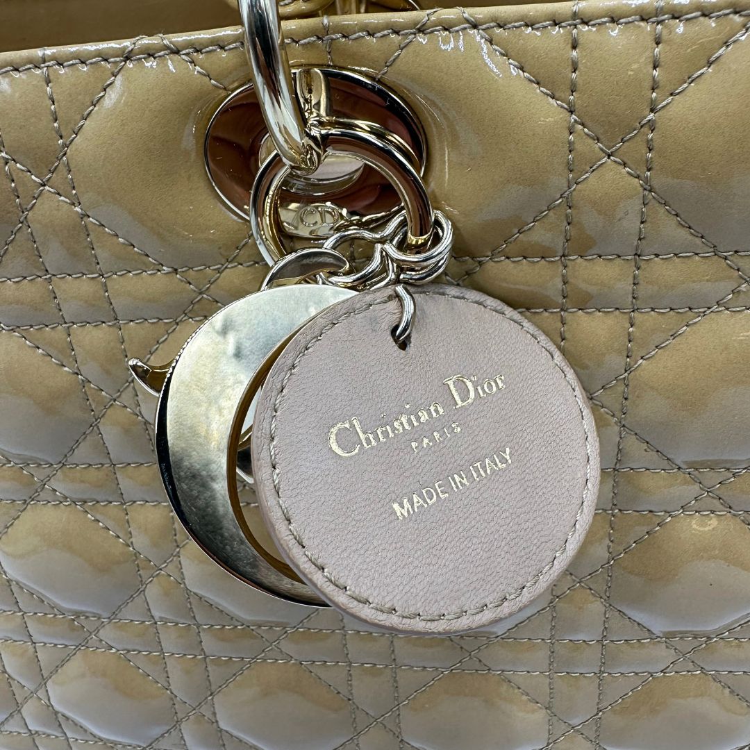 Borsa Lady Dior Large in pelle verniciata in trama cannage giallo ocra chiaro. Doppi manici rigidi e una tracolla amovibile, rifinita con parti metalliche argentate. Completa di corredo. Originale, usato, in condizioni ottime. 