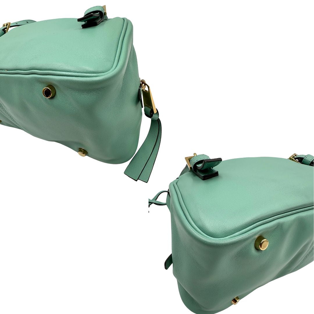 Angoli Bauletto Versace in pelle verde tiffany con parti metalliche dorate e doppi manici leggermente regolabili. Rifinita con logo lettering sul front e medusa sulla clochette rimovibile. Completo di corredo. Originale, usato, in condizioni ottime. 