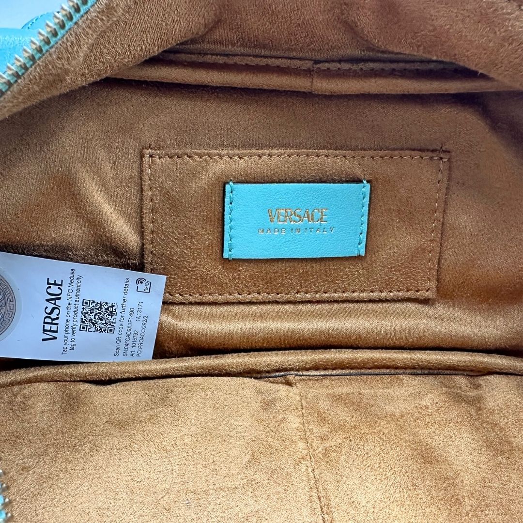 Interno Bauletto Versace in pelle verde tiffany con parti metalliche dorate e doppi manici leggermente regolabili. Rifinita con logo lettering sul front e medusa sulla clochette rimovibile. Completo di corredo. Originale, usato, in condizioni ottime. 