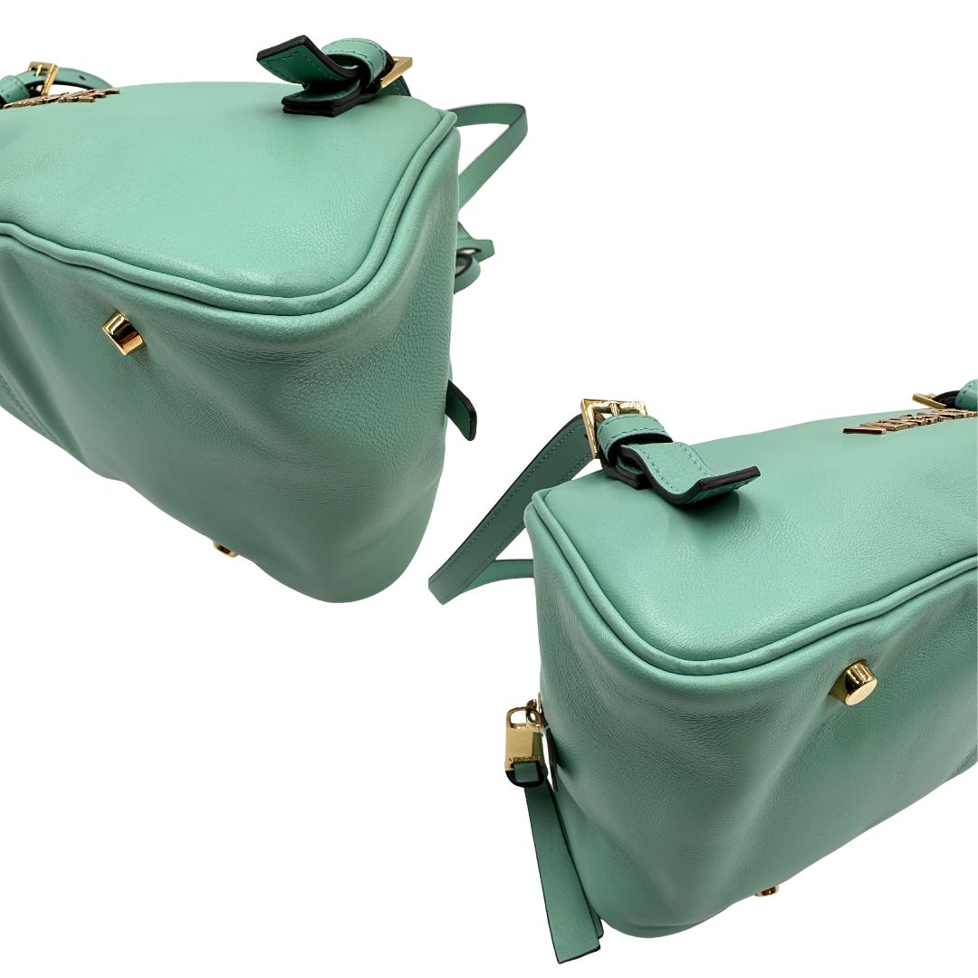 Angoli Bauletto Versace in pelle verde tiffany con parti metalliche dorate e doppi manici leggermente regolabili. Rifinita con logo lettering sul front e medusa sulla clochette rimovibile. Completo di corredo. Originale, usato, in condizioni ottime. 