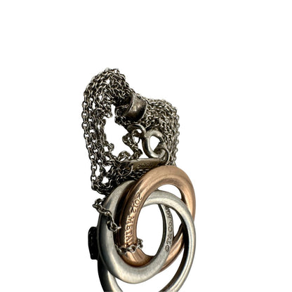 Collana Tiffany&amp;Co. Three Interlocking Rings della collezione Elsa Peretti , in argento 925 con tre ciondoli a cerchio intrecciati, di cui uno color oro. Completo di sacchetto antipolvere. Originale, usato, in condizioni ottime. 