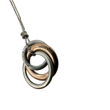 Collana Tiffany&amp;Co. Three Interlocking Rings della collezione Elsa Peretti , in argento 925 con tre ciondoli a cerchio intrecciati, di cui uno color oro. Completo di sacchetto antipolvere. Originale, usato, in condizioni ottime. 