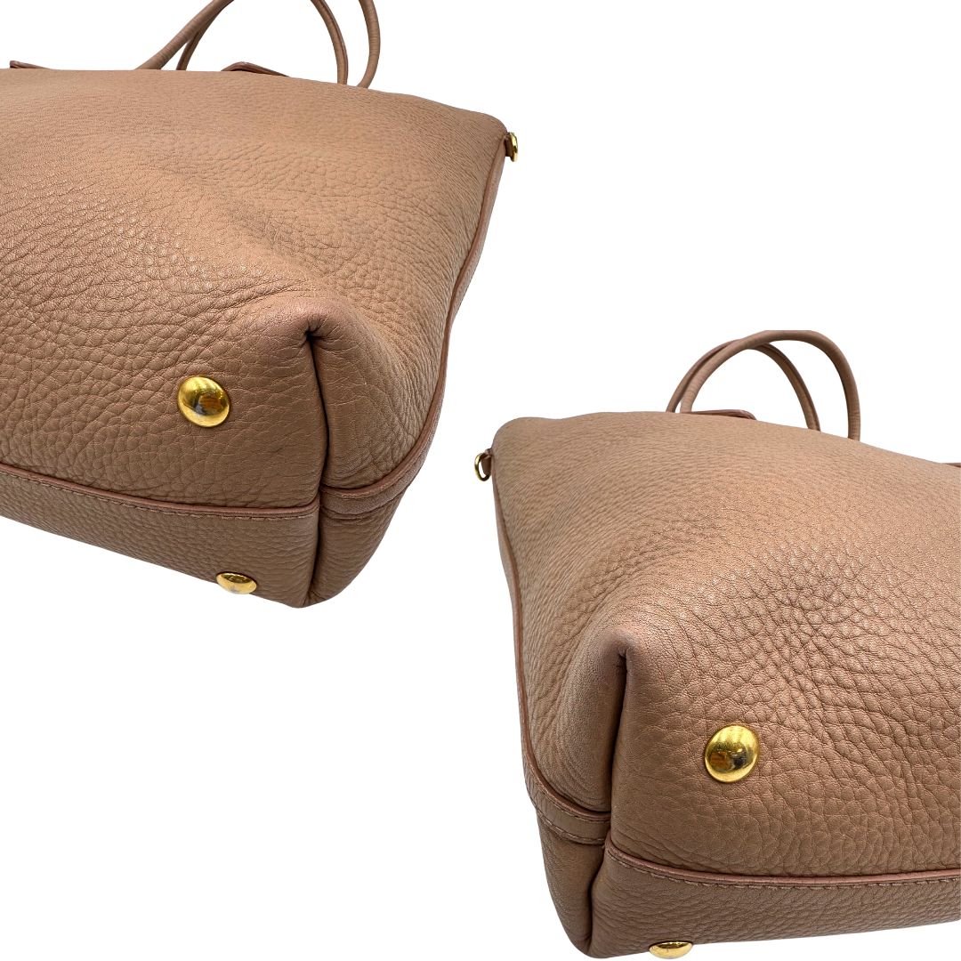 angoli Borsa Miu Miu in pelle martellata rosa color cipria munita di una pochette estraibile e amovibile color melanzana e doppi manici. Completa di dustbag. 