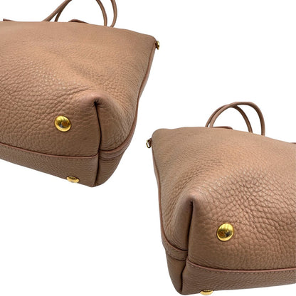 angoli Borsa Miu Miu in pelle martellata rosa color cipria munita di una pochette estraibile e amovibile color melanzana e doppi manici. Completa di dustbag. 