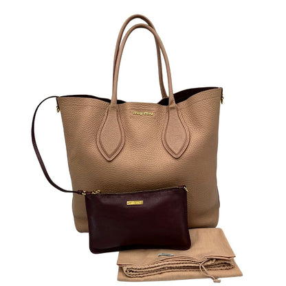  Borsa Miu Miu in pelle martellata rosa color cipria munita di una pochette estraibile e amovibile color melanzana e doppi manici. Completa di dustbag.