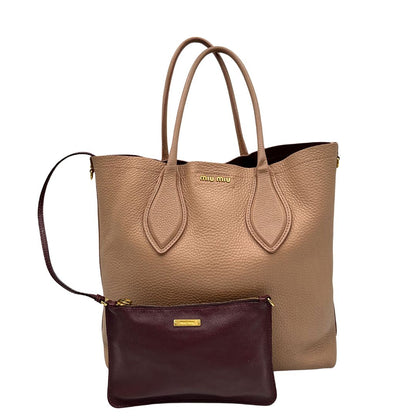 front Borsa Miu Miu in pelle martellata rosa color cipria munita di una pochette estraibile e amovibile color melanzana e doppi manici. Completa di dustbag.