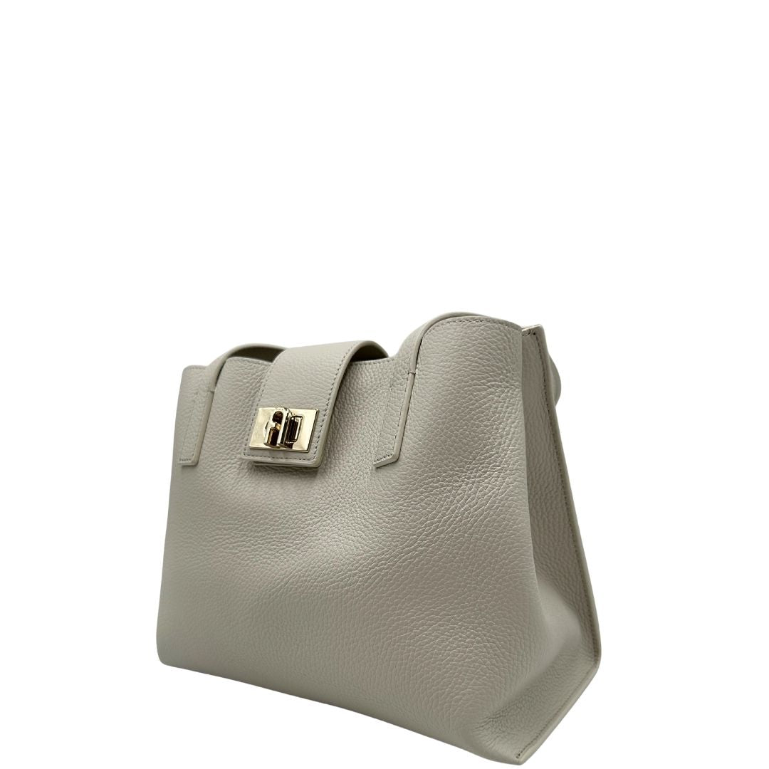 lato Borsa Furla in pelle martellata color bianco latte con parti metalliche oro chiaro; munita di doppi manici, indossabile a spalla 