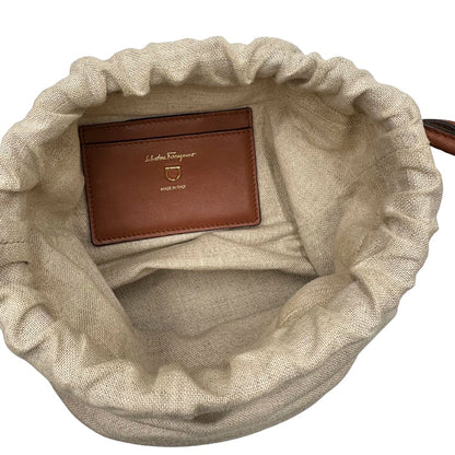 Interno Borsa a secchiello Salvatore Ferragamo in pelle marrone cognac con sacca interna in tela beige con chiusura a coulisse. Munita di un manico stondato e tracolla, parti metalliche dorate. Completa di dustbag. Originale, usato, in condizioni ottime. 