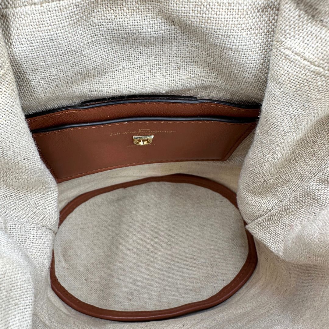 Interno Borsa a secchiello Salvatore Ferragamo in pelle marrone cognac con sacca interna in tela beige con chiusura a coulisse. Munita di un manico stondato e tracolla, parti metalliche dorate. Completa di dustbag. Originale, usato, in condizioni ottime. 