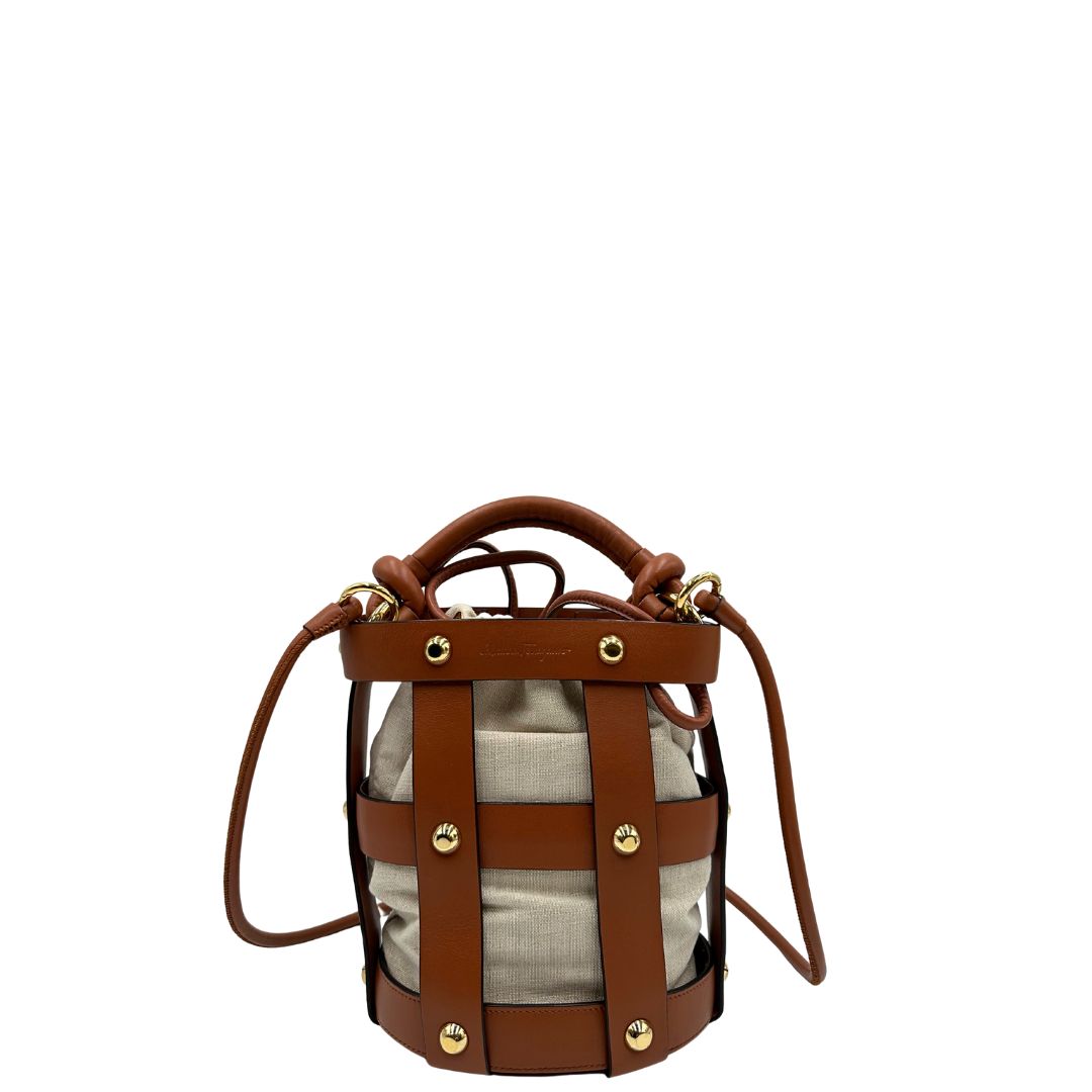 Borsa a secchiello Salvatore Ferragamo in pelle marrone cognac con sacca interna in tela beige con chiusura a coulisse. Munita di un manico stondato e tracolla, parti metalliche dorate. Completa di dustbag. Originale, usato, in condizioni ottime. 