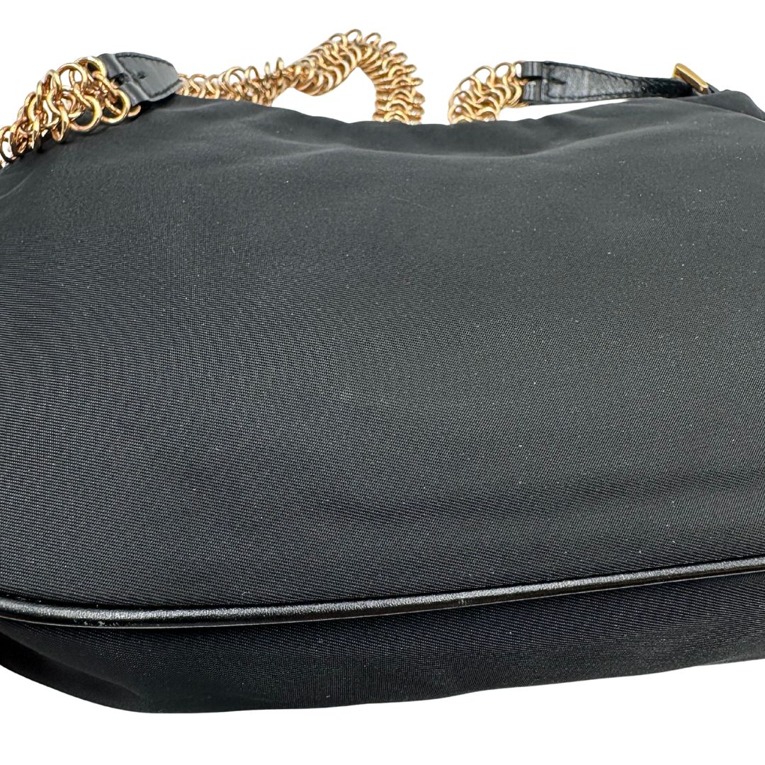 Borsa Prada in nylon nero con parti metalliche dorate e finiture in pelle tono su tono. Munta di un manico in catena leggermente regolabile con fibbie, e rifinita con classico logo triangolare sul front. Completa di dustbag. Originale, usato, in condizioni ottime. 