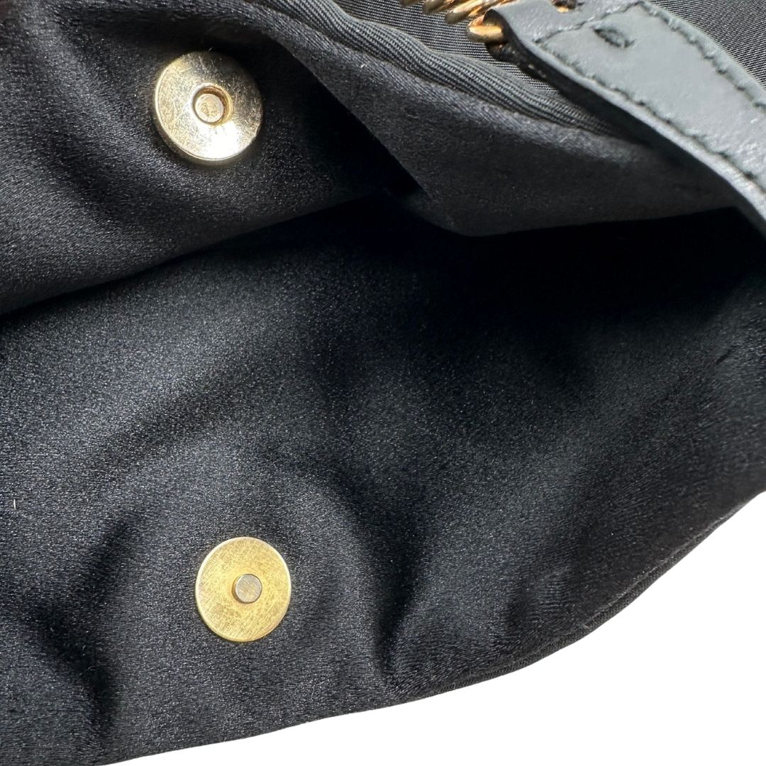 Borsa Prada in nylon nero con parti metalliche dorate e finiture in pelle tono su tono. Munta di un manico in catena leggermente regolabile con fibbie, e rifinita con classico logo triangolare sul front. Completa di dustbag. Originale, usato, in condizioni ottime. 