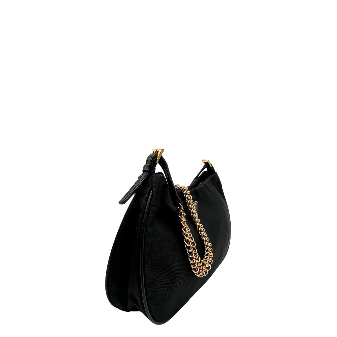 Laterale Borsa Prada in nylon nero con parti metalliche dorate e finiture in pelle tono su tono. Munta di un manico in catena leggermente regolabile con fibbie, e rifinita con classico logo triangolare sul front. Completa di dustbag. Originale, usato, in condizioni ottime. 